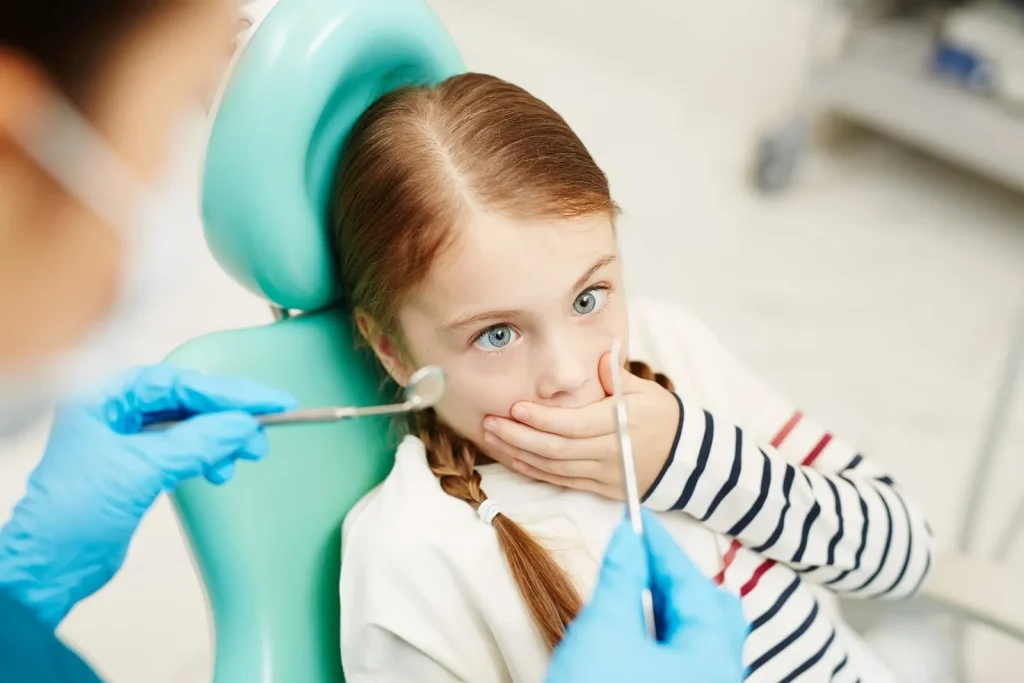 Menina na cadeira do dentista com medo, ansiedade e odontologia